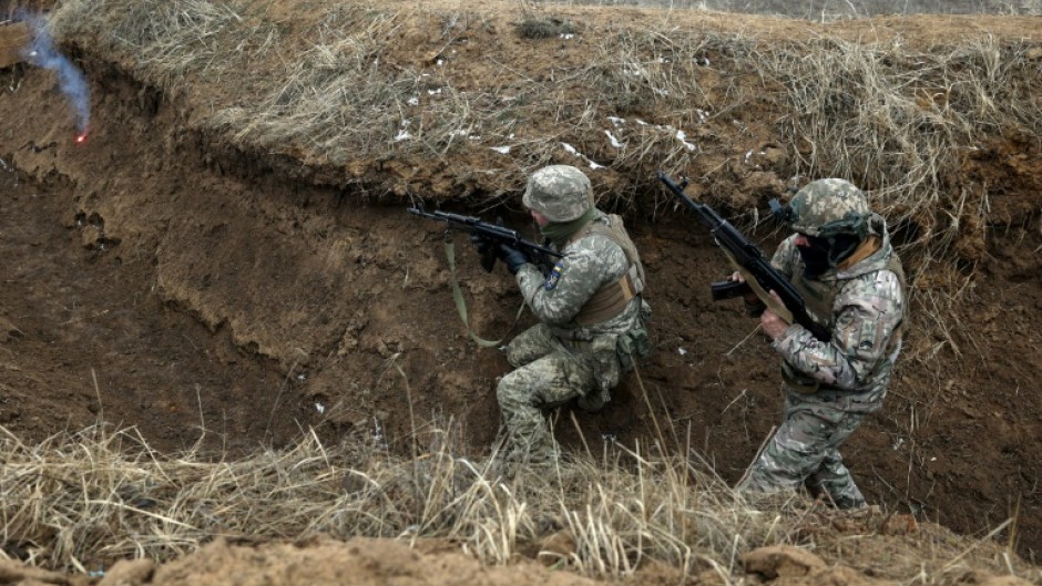 Ukrainian servicemen take position in a trench during a military training exercise near the front line in the Donetsk region