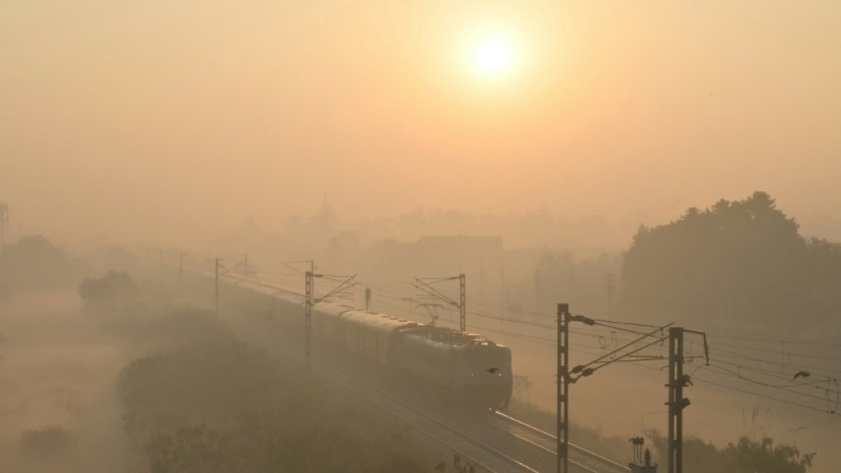 A train passes through heavy smog in India, where authorities have ordered an investigation into a runaway train incident