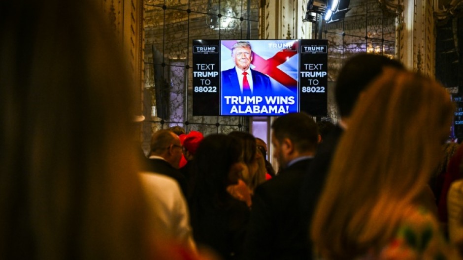 Supporters of former US President and 2024 presidential hopeful Donald Trump watch a screen announcing "Trump wins Alabama" as they attend a Super Tuesday election night watch party at Mar-a-Lago Club in Palm Beach, Florida, on March 5, 2024