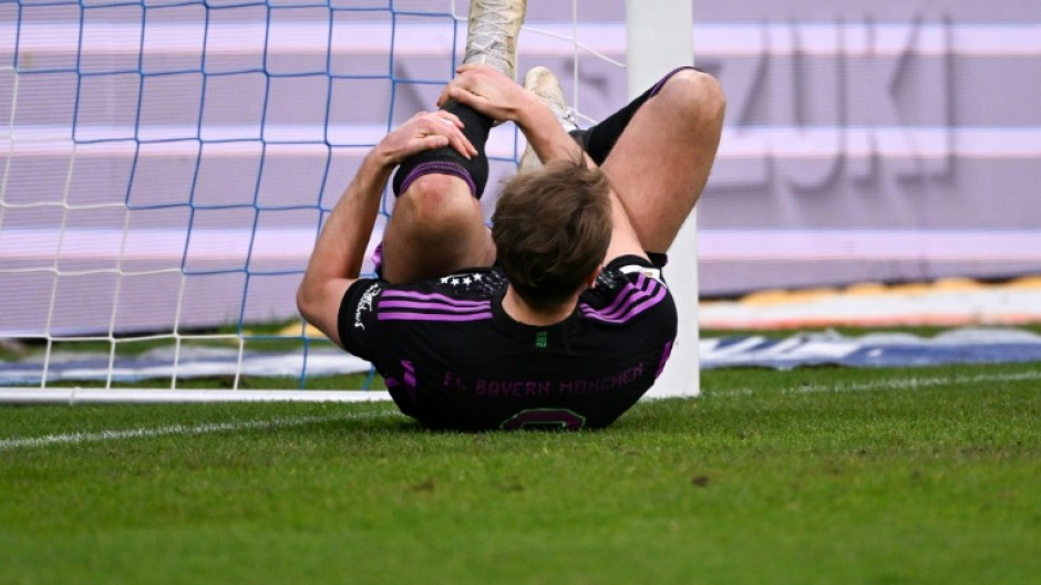 Bayern Munich forward Harry Kane holds his leg during Saturday's 5-2 win at Darmstadt.