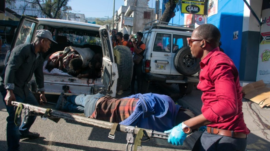 Paramedics carry the body of a person killed by gang members in Petionville, Port-au-Prince, Haiti