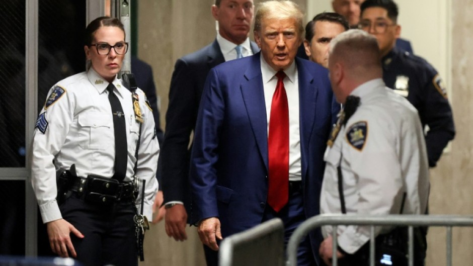 Former US president Donald Trump arrives for a hearing to set a date for his trial for allegedly covering up hush money payments to  a porn star