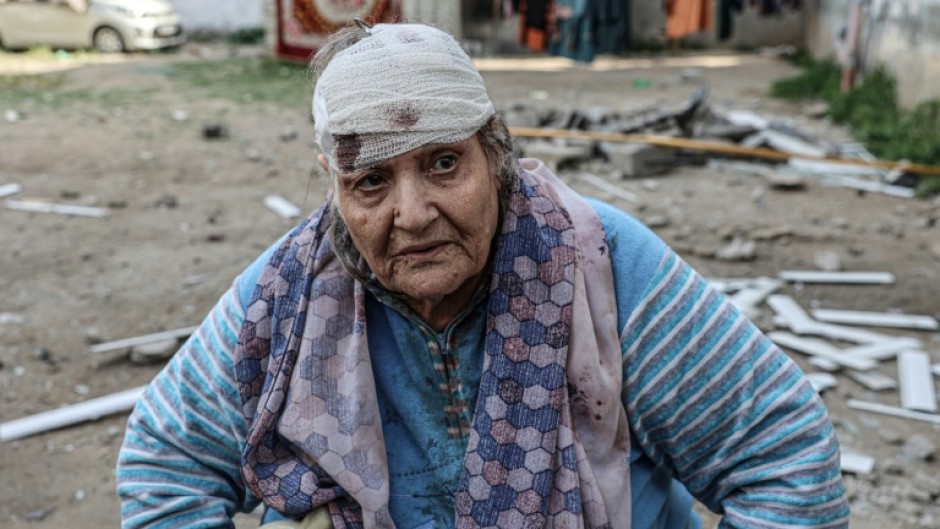 Palestinian Hoda al-Arouqi, 75, who was injured during overnight Israeli bombardment, inspects the damage to her home in Rafah in the southern Gaza Strip on March 25, 2024