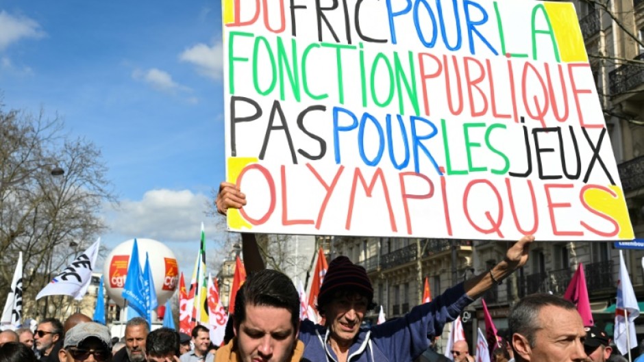 A protester holds a banner reading 'Cash for civil services, not for the Olympic Games' during a demonstration last week