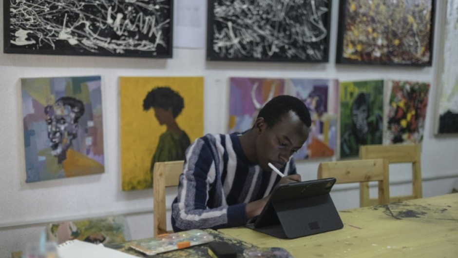 Manzi Yvan Bryan, a member of the Rwandan 'Art for Memories' project, works on a portrait of a genocide victim