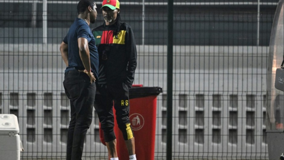 Cameroon football federation president Samuel Eto'o (L) talks to former coach Rigobert Song during an AFCON training session