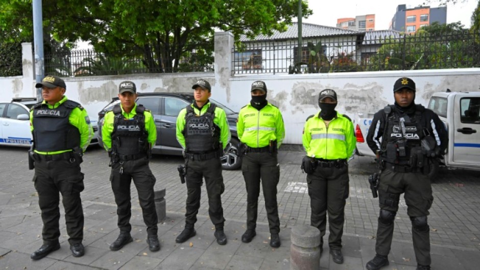 Police officers stand outside the Mexican embassy in Quito 