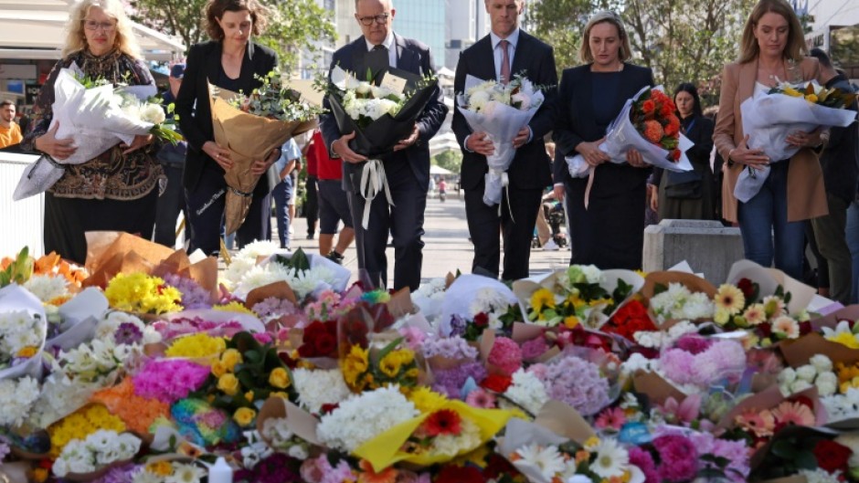 Australian Prime Minister Anthony Albanese (C, with NSW premier Chris Minns) leave flowers in tribute to the victims of the shopping mall attack