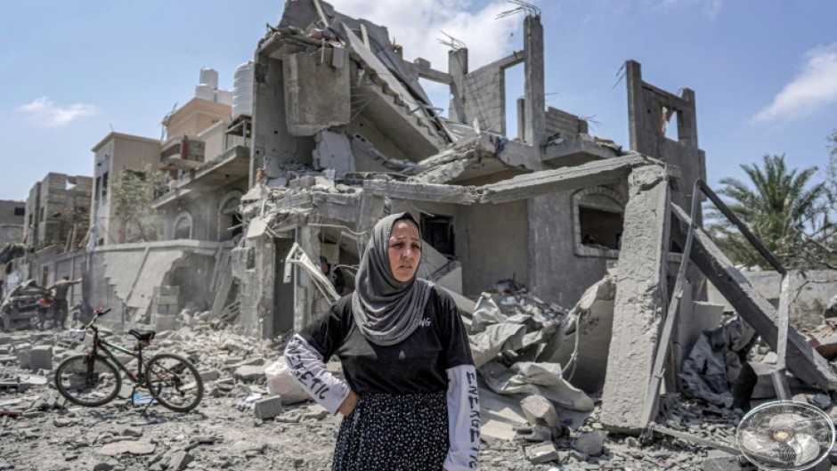 A woman stands amid rubble in the Maghazi camp for Palestinian refugees in the central Gaza Strip on April 15, 2024