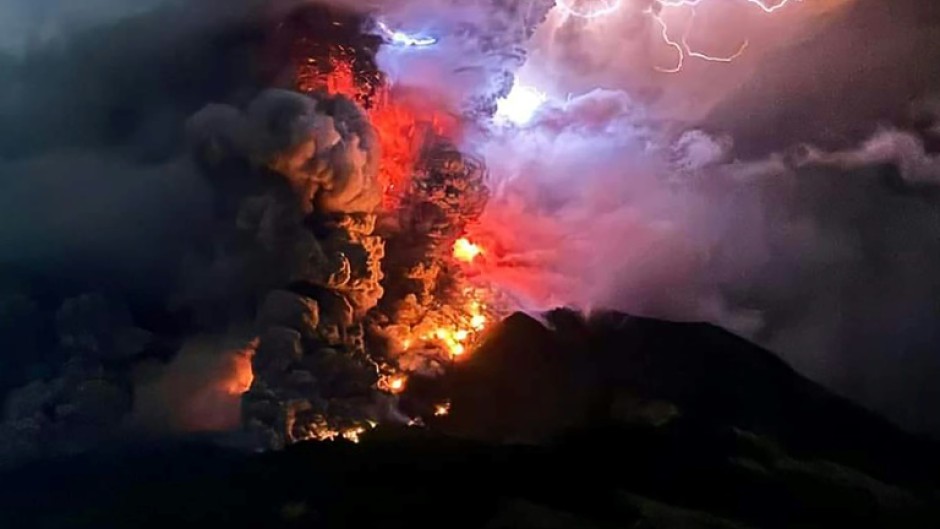The crater of Mount Ruang flamed with lava against a backdrop of lightning bolts overnight after erupting five times