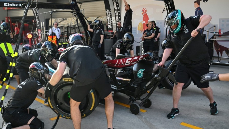 Mechanics practice pit stops with the car of Mercedes' British driver Lewis Hamilton ahead of the Formula One Chinese Grand Prix in Shanghai