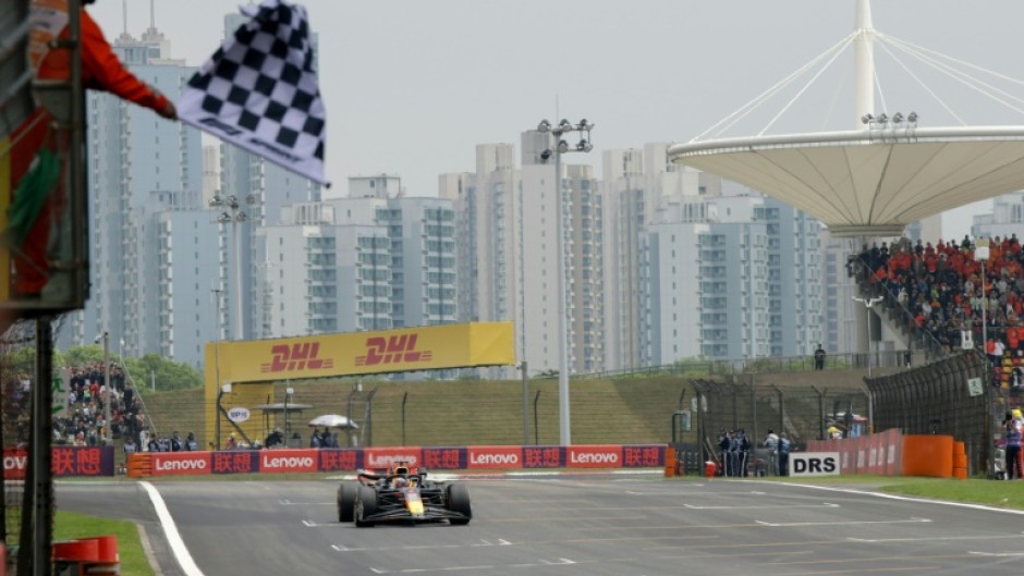 Red Bull Racing's Dutch driver Max Verstappen takes the chequered flag in Shanghai