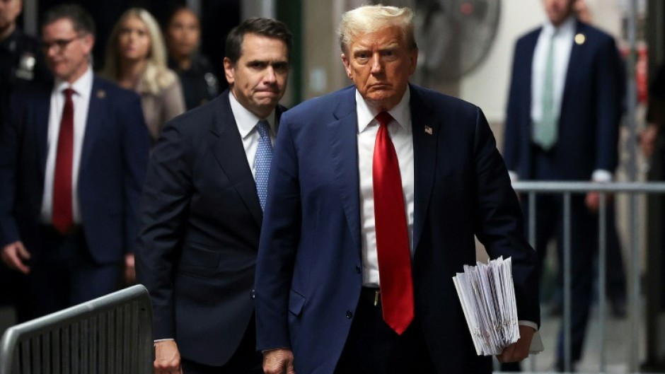 Former US President Donald Trump, with attorney Todd Blanche (L), walks toward the press to speak after attending his criminal trial for alleged business record fraud