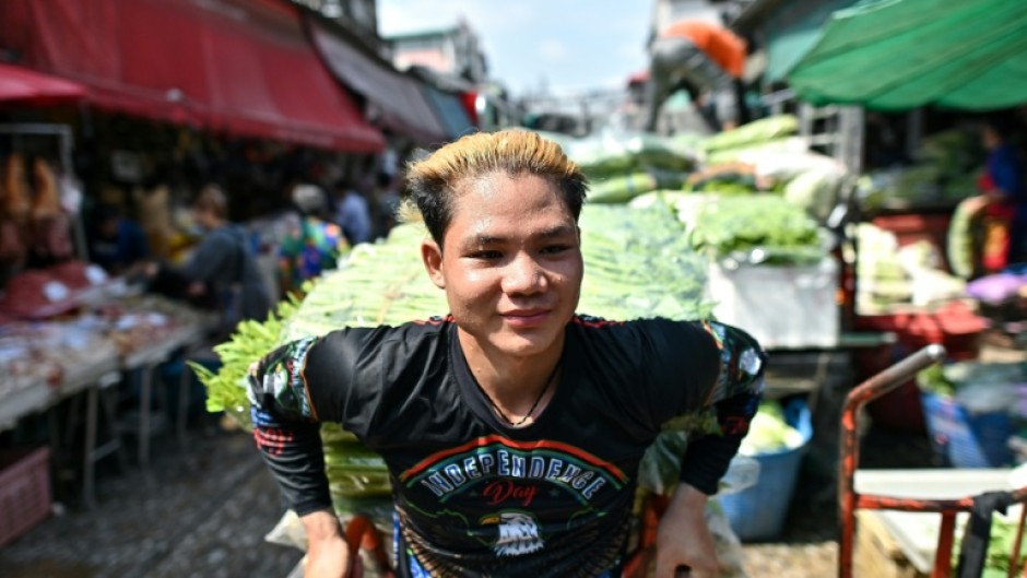 A vendor sweats as he pulls a vegetable cart at Bangkok's biggest fresh market, with people sweltering through heatwaves across Southeast and South Asia