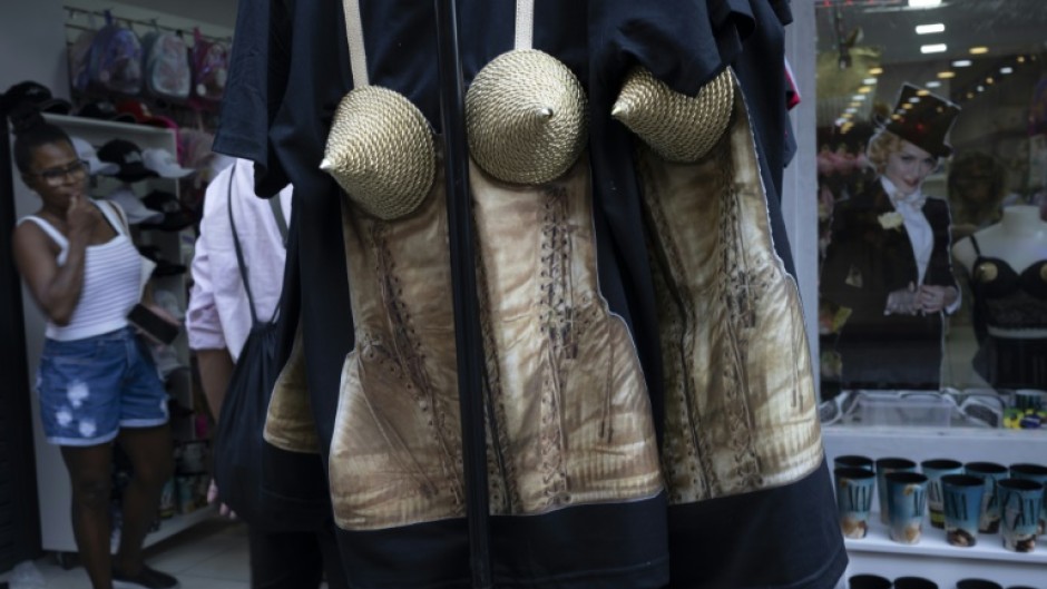 A woman looks at merchandise inspired by US pop star Madonna, including a conical corset top, at a shop in Rio de Janeiro