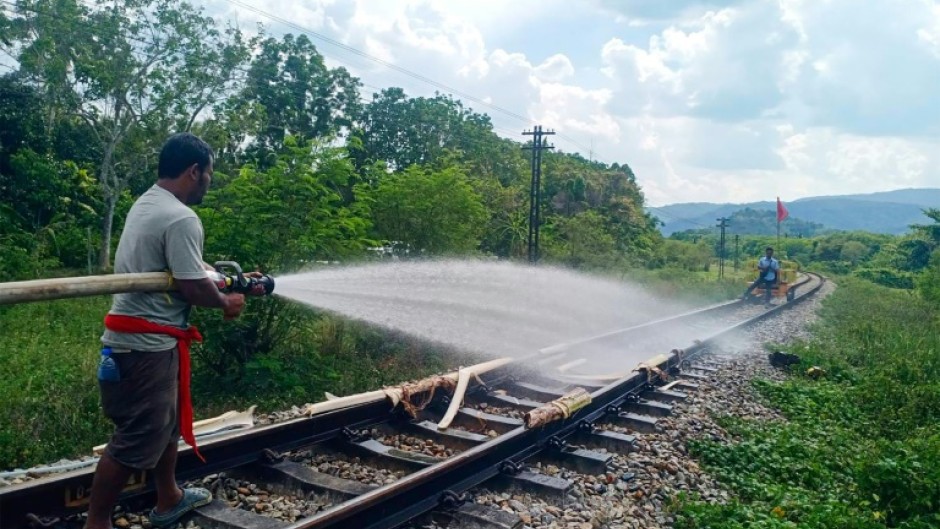 Thai railway workers doused the melting tracks with water to try to bend them back into shape