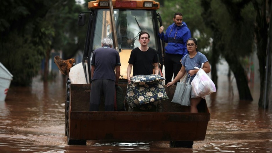 A construction vehicle carries evacuees from a flooded area of the Sao Geraldo neighborhood in Porto Alegre, on May 4, 2024
