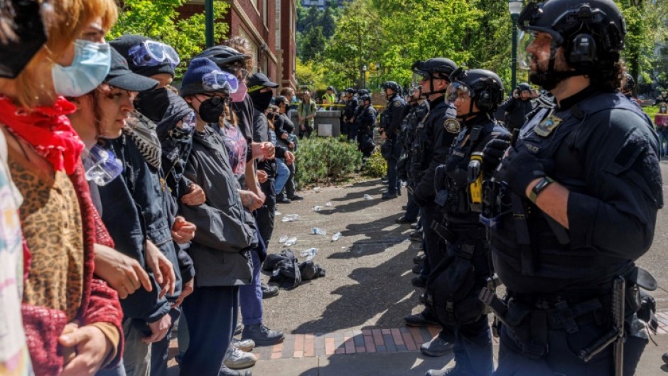 Pro-Palestinian students and activists face police officers after protesters were evicted from the library on campus earlier in the day at Portland State University in Portland, Oregon, on May 2, 2024