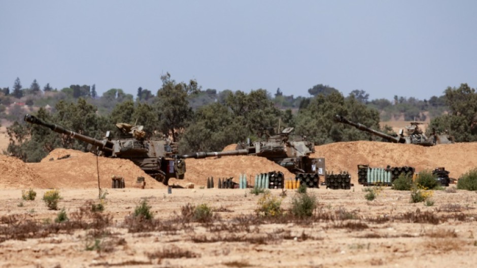 Israeli troops man a position with mobile artillery units in southern Israel near the border with the Gaza Strip