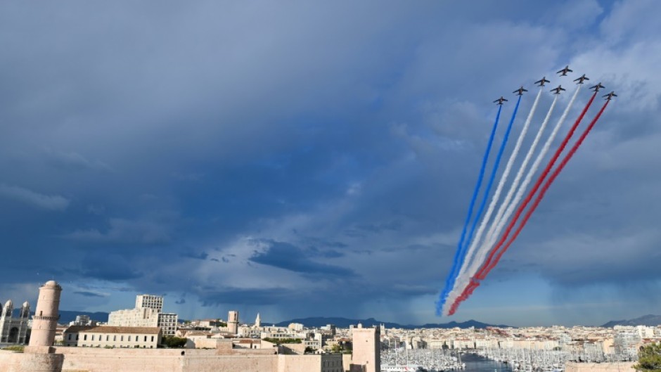 The French Air Force display team  sprays the colours of the French flag above Marseille's Old Port as the Olympic flame arrives
