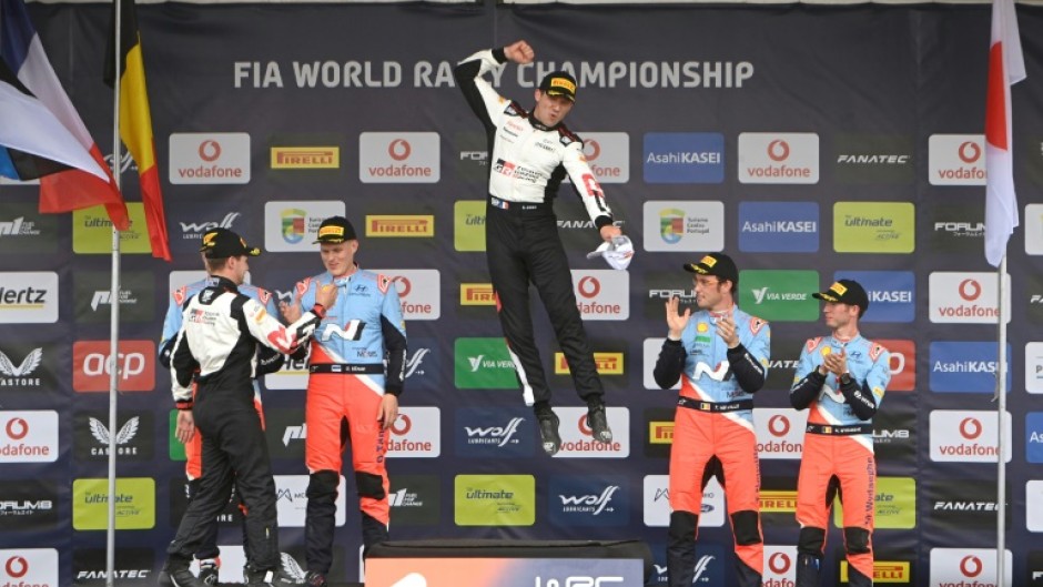 Sebastien Ogier (C) celebrates a record sixth Rally of Portugal victory