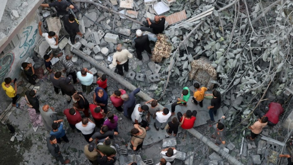Palestinians search for survivors after a strike on the Al-Daraj neighbourhood in Gaza City