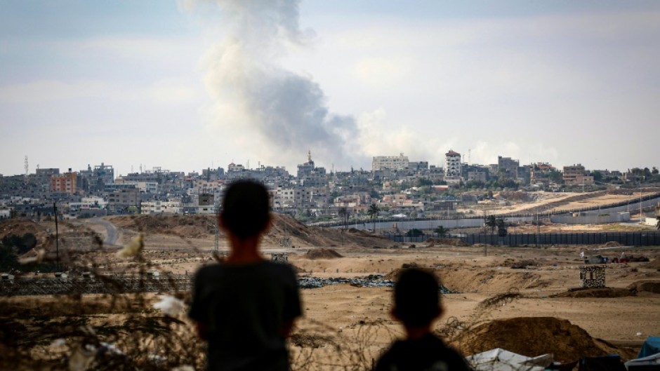 Boys watch smoke billowing during Israeli strikes east of Rafah