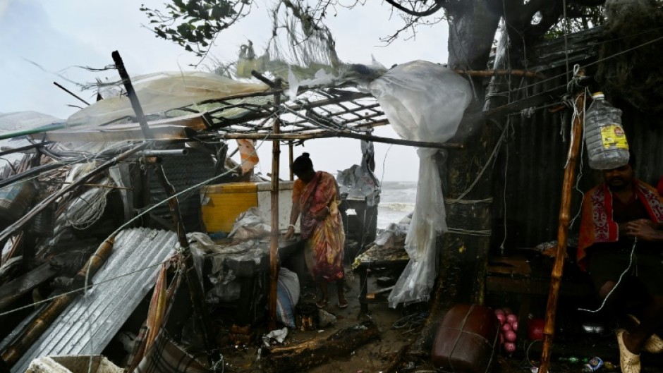 A man carries a child as he walks towards a shelter: cyclones have killed hundreds of thousands of people in Bangladesh in recent decades, but better forecasting and more effective evacuation planning have dramatically reduced the death toll