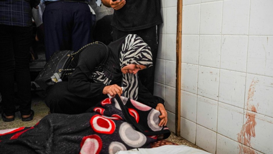 A woman mourns over the body of a relative at Al-Aqsa Martyrs Hospital in Deir al-Balah