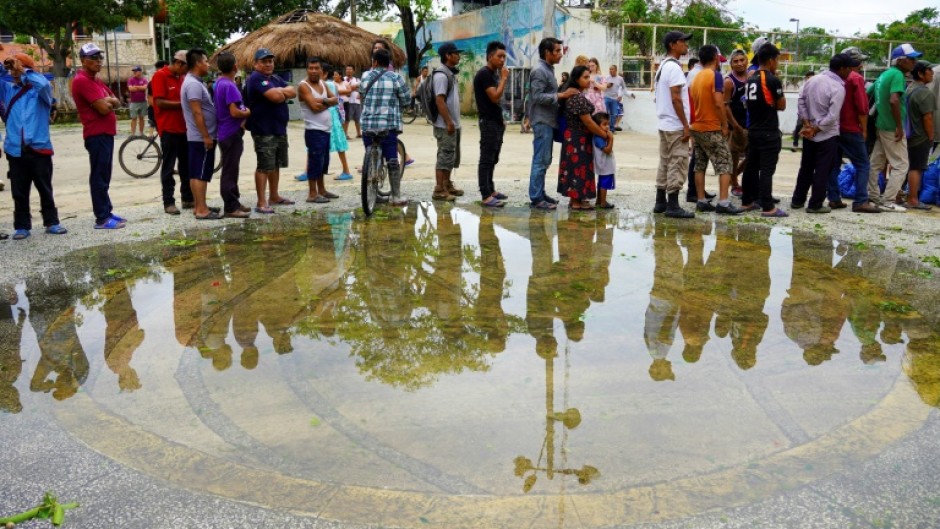 Residents in Tulum, Mexico, queue to receive food rations provided by the Mexican army following the passage of Hurricane Beryl 