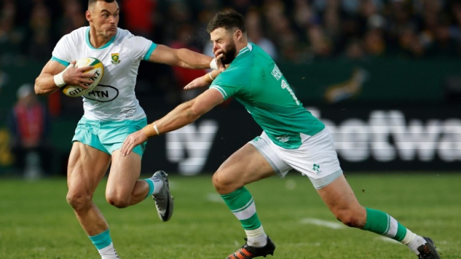 South African Jesse Kriel (L) hands off fellow centre Robbie Henshaw of Ireland during the first Test in Pretoria.
