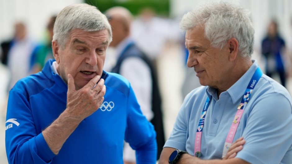 International Olympic Committee President Thomas Bach speaks to IOC member Juan Antonio Samaranch Junior at the Athletes' Village