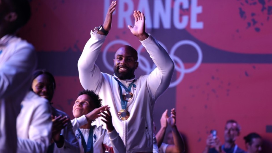 Teddy Riner and the gold medal-winning French judo team celebrate with supporters at Club France