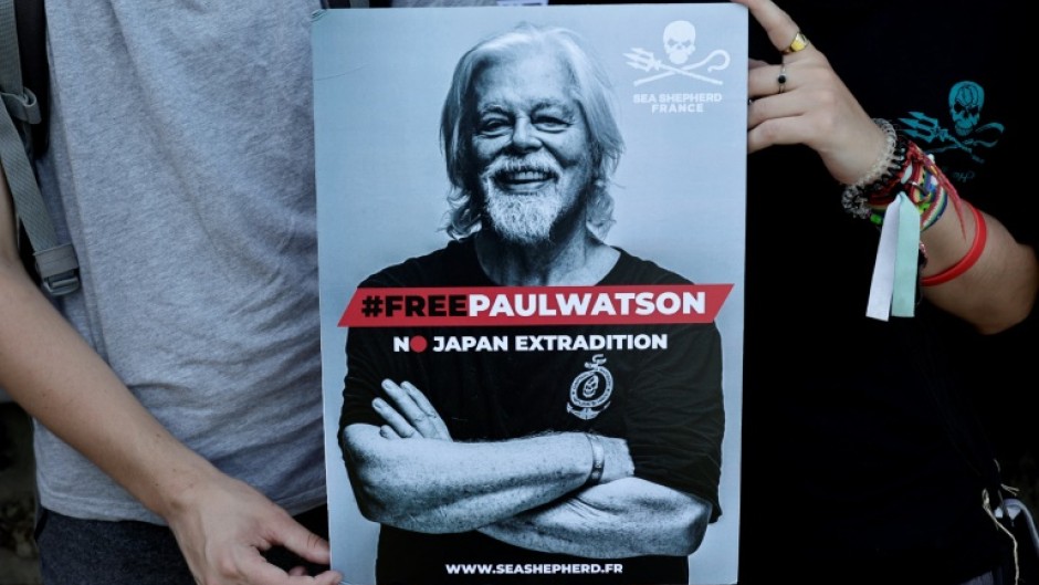 Protesters in Paris hold a placard calling for Watson's release