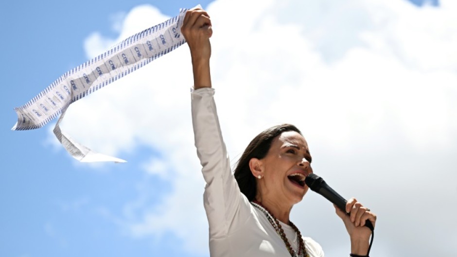 Venezuelan opposition leader Maria Corina Machado speaks to supporters while holding up electoral records during a rally in Caracas on August 28, 2024