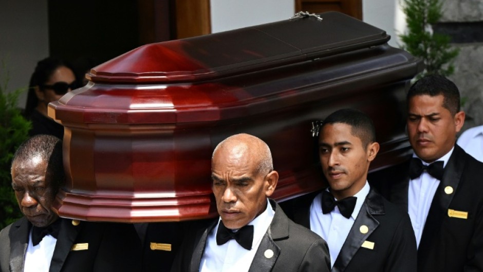 Employees from a funeral parlour carry the coffin of late Peru's former president Alberto Fujimori 
