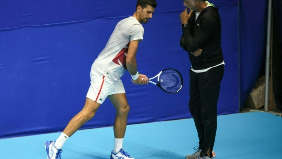 Italian fitness coach Marco Panichi (R) working with Serbia's Novak Djokovic during the 2022 Tel Aviv Open