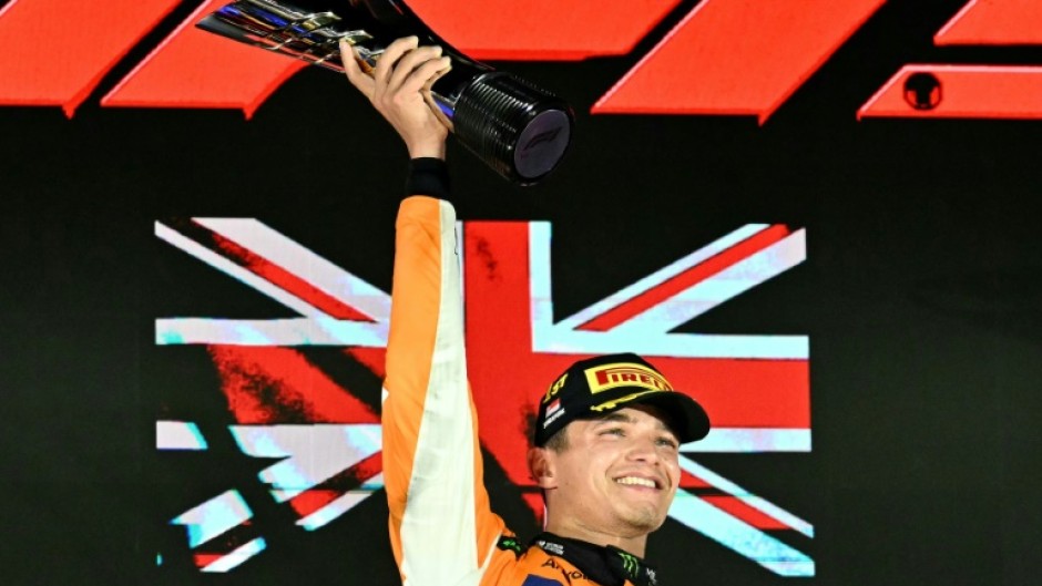 McLaren's British driver Lando Norris (C) celebrates winning on the podium after the Formula One Singapore Grand Prix