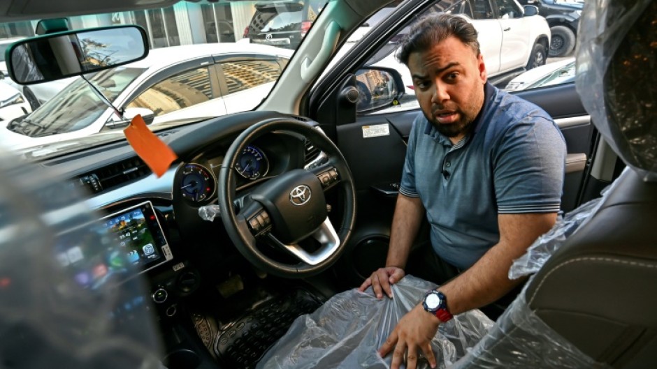 Car dealer Fahad Nazir shows AFP the inside of a Toyota Hilux pick-up truck, locally known as a 'Dala', at his lot in Karachi