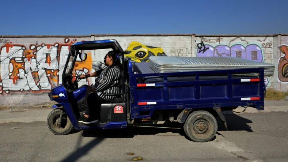 Marco Antonio Terron and his daughter Maria del Mar ride their three-wheeled scrap collection vehicle near Mexico City