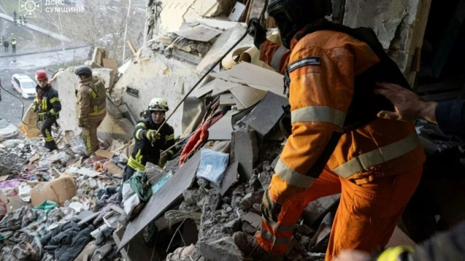 Ukrainian rescuers clearing rubble from a residential building following the overnight drone attack