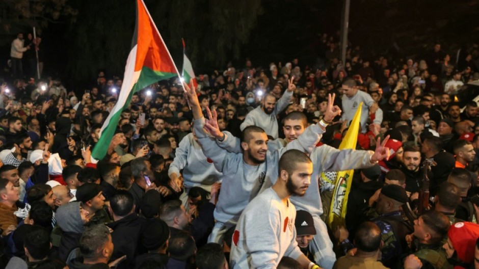 A crowd welcomes Palestinians formerly jailed by Israel as they arrive in a Red Cross convoy to Ramallah in the occupied West Bank