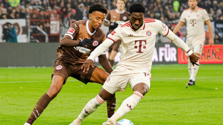 Bayern Munich defender Alphonso Davies, R, has signed a five-year extension with the club.