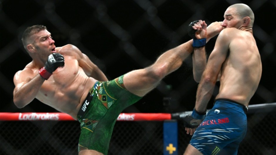 South Africa's Dricus du Plessis (L) and Sean Strickland exchange blows in the UFC middleweight title bout