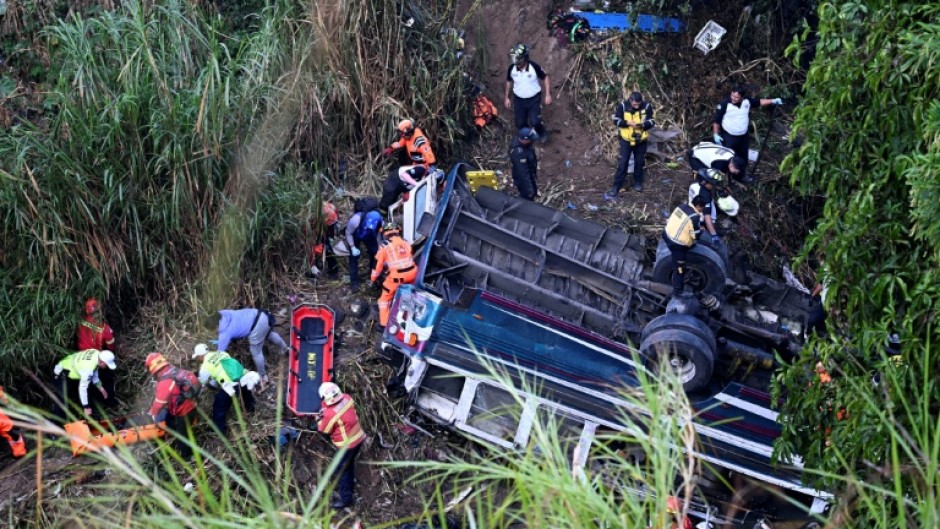 Firefighters and police work at the scene of a bus crash in Guatemala City on February 10, 2025