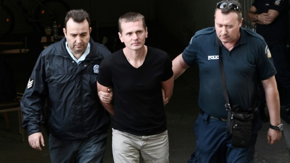 Russian Alexander Vinnik (C) is escorted by police officers as he arrives at a courthouse in Thessaloniki, Greece in 2017
