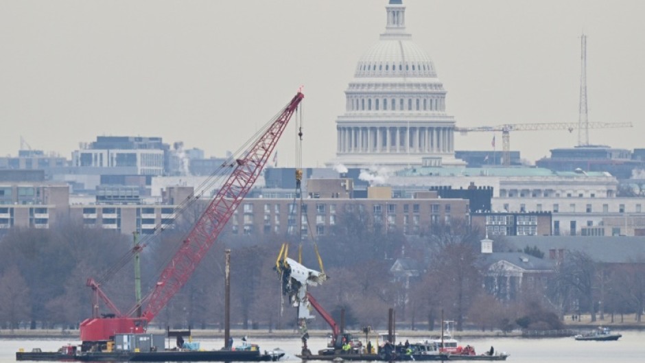A crane removes wreckage from the Potomac River of American Eagle Flight 5342, which collided with a US Army helicopter near Ronald Reagan National Airport
