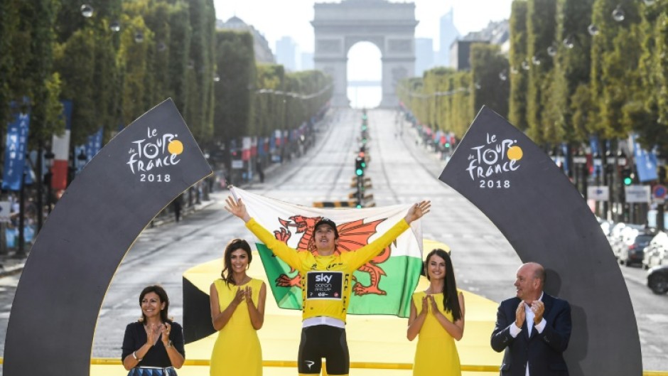 Geraint Thomas holds the Welsh flag aloft after his 2018 Tour de France triumph