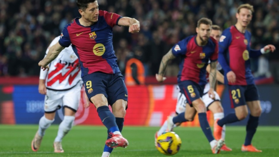 Robert Lewandowski converts the penalty that gave Barcelona victory over Rayo Vallecano and top spot in La Liga