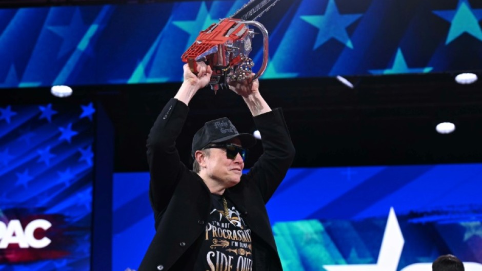 Elon Musk holds a chainsaw reading "Long live freedom, damn it" during the annual Conservative Political Action Conference (CPAC), a gift from Argentina's Javier Milei